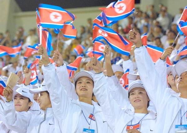 North Korean women wave their country's flags during a soccer match at Changwon stadium in Changwon, South Korea, during the Busan Asian Games. 