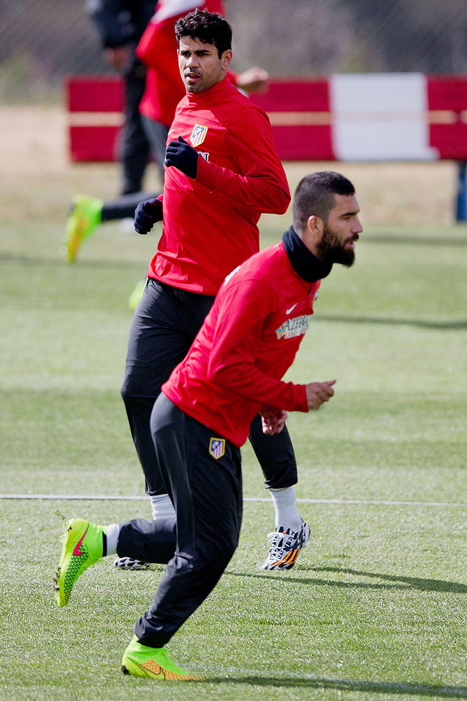 Diego Costa (left) of Atletico de Madrid excersises with his teammate Arda Turan (right) during a training session at Los Angeles de San Rafael training ground in Segovia, Spain on Thursday