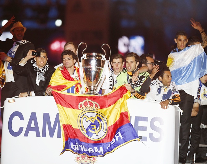 Real Madrid players celebrate on top of an open bus as they arrive at the Cibeles square after winning their Champions League final