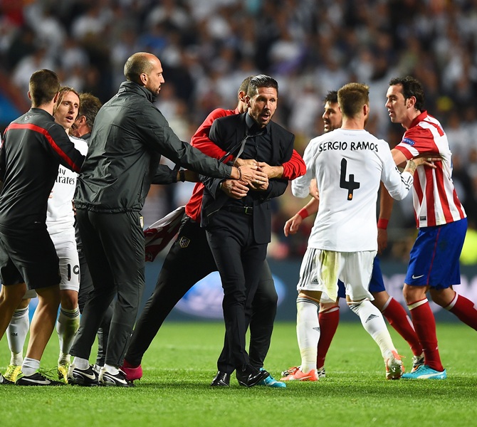 Diego Simeone, Coach of Club Atletico de Madrid is restrained as he clashes with Sergio Ramos of Real Madrid