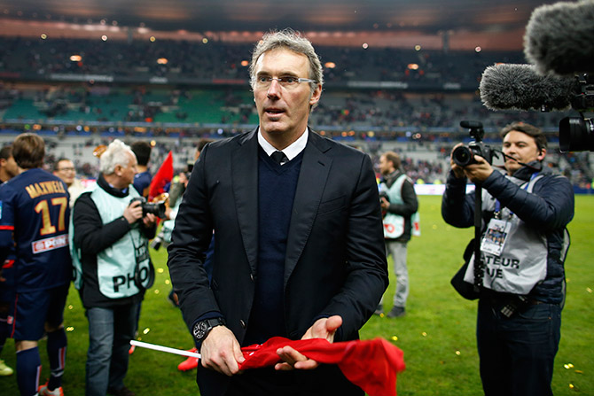 Paris St Germain's coach Laurent Blanc looks on while he celebrates defeating Olympique Lyon in the French League Cup final