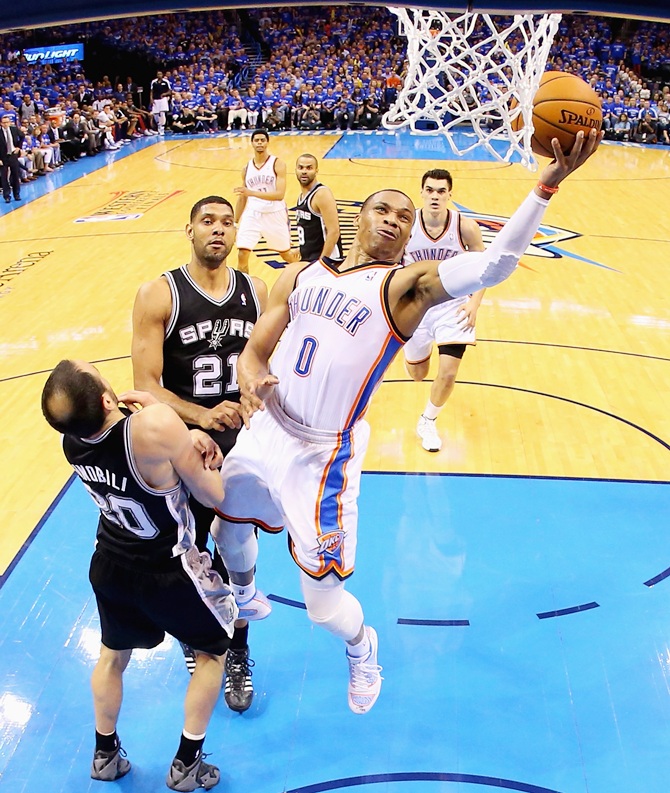 Russell Westbrook of the Oklahoma City Thunder drives to the basket against Manu Ginobiliof the San Antonio Spurs