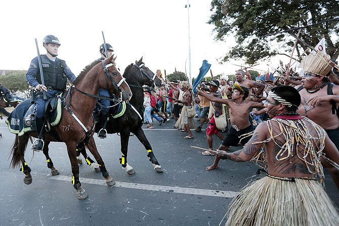 Police confront native Brazilians to prevent them from marching towards the Mane Garrincha soccer stadium during a demonstration in Brasilia on Tuesday