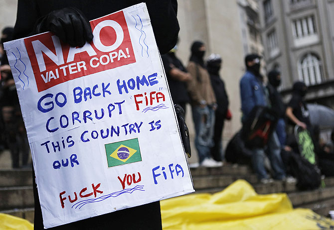 A demonstrator holds a sign during a protest against the 2014 World Cup in Sao Paulo on Saturday
