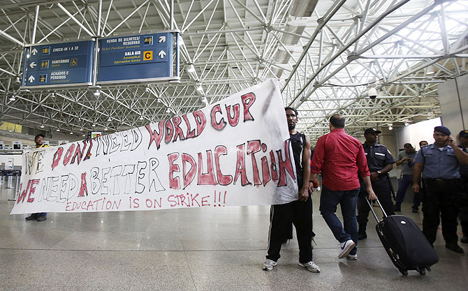 Teachers hold a banner during a protest against the World Cup after the arrival of the Brazilian soccer players at the international airport in Rio de Janeiro on Monday
