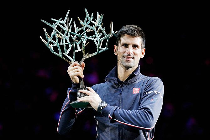 Novak Djokovic of Serbia poses with the trophy after victory against Milos Raonic of Canada in the Paris Masters final on Sunday