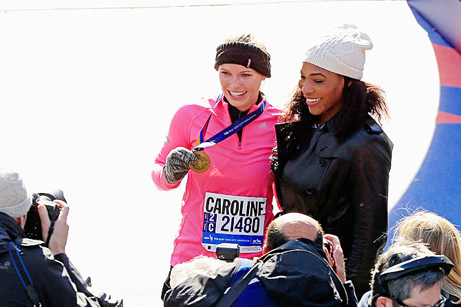 Caroline Wozniacki celebrates with Serena Williams at the finish line at the New York Marathon on Sunday