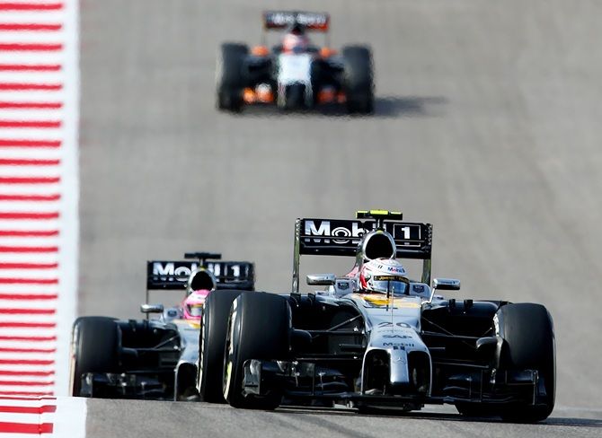 Kevin Magnussen of Denmark and McLaren leads Jenson Button of Great Britain and McLaren