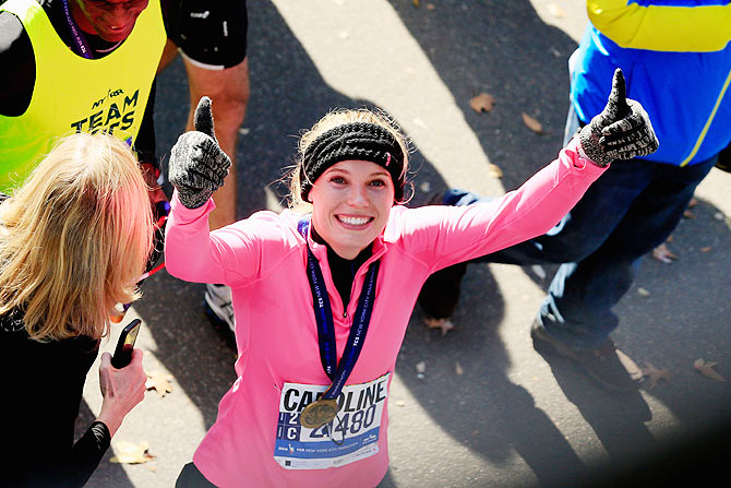 Caroline Wozniacki gives the thumbs up after crossing the finish line at the New York Marathon on Sunday