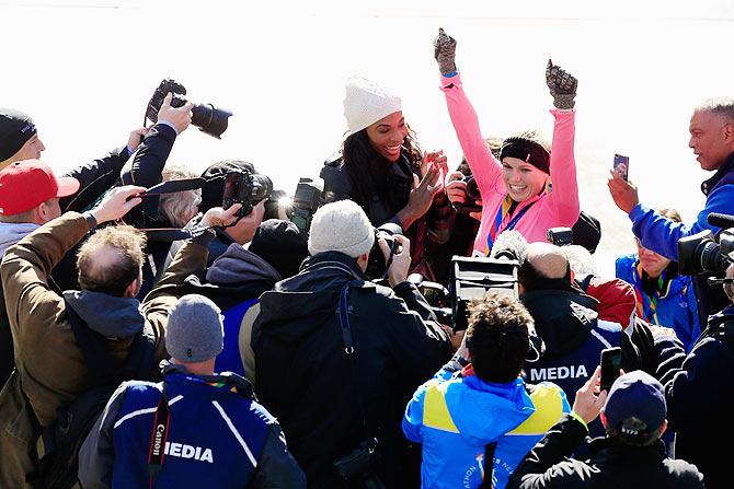 Serena Williams celebrates as Caroline Wozniacki crosses the finish line at the New York Marathon on Sunday