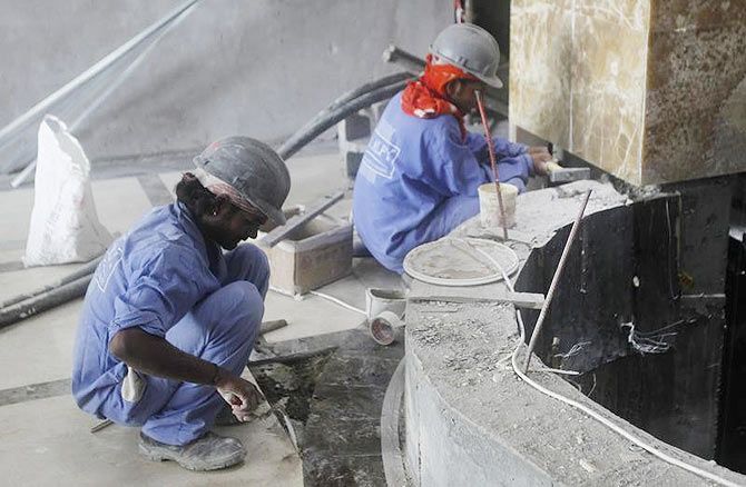 Labourers work at a construction site in Doha