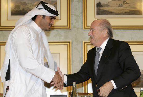 FIFA President Sepp Blatter (right) shakes hands with Qatar's 2022 World Cup Bid Chief Sheikh Mohammed Al-Thani (left) at a news conference