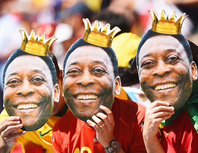 Fans hold up cutouts of Pele