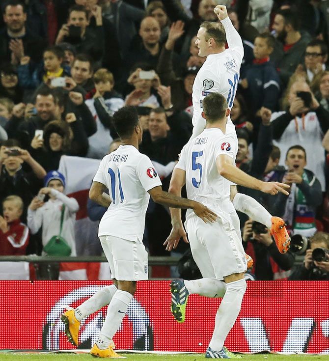 England captain Wayne Rooney (top) celebrates with teammates after scoring from the penalty spot during their Euro 2016 Group E qualifying match against Slovenia at Wembley Stadium in London on Saturday