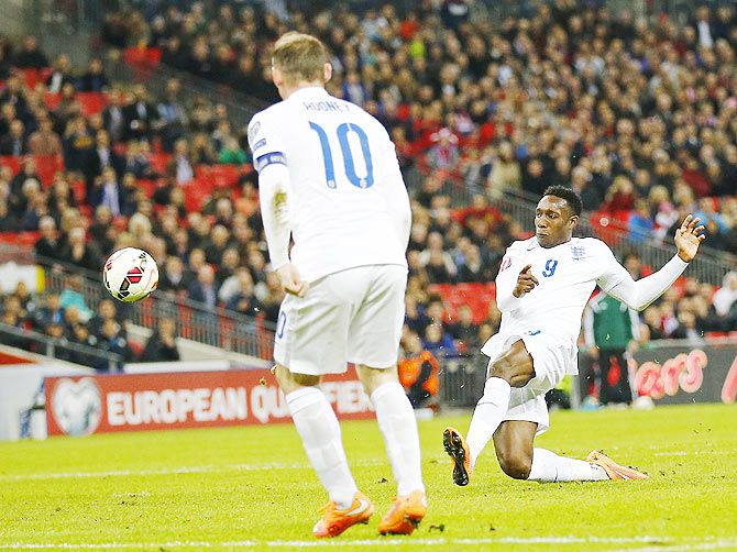 England's Danny Welbeck (right) shoots to score during their Euro 2016 Group E qualifying match against Slovenia 