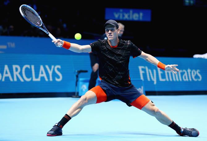 Tomas Berdych of the Czech Republic stretches to play a forehand against Stanislas Wawrinka of Switzerland