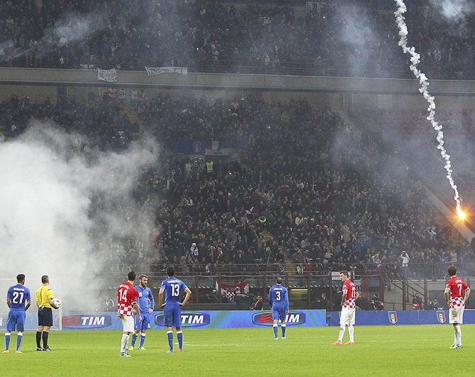 Play is stopped after fireworks are thrown onto the pitch by the Croatia fans