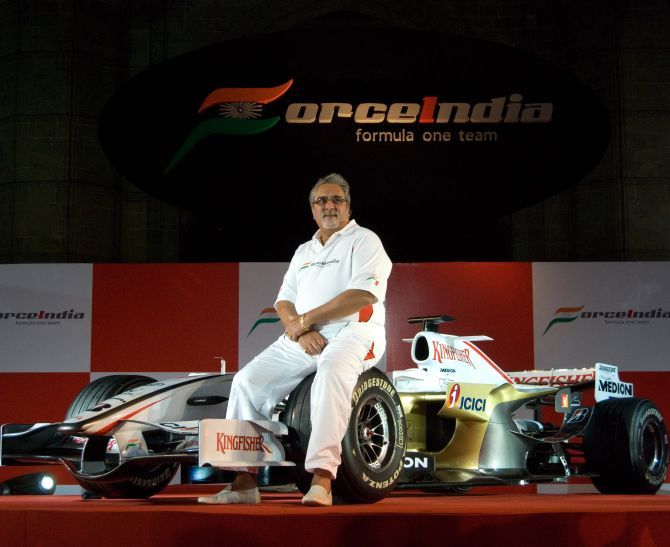 Chairman of Force India F1 team, Vijay Mallya, poses with the Force India Formula One Team car