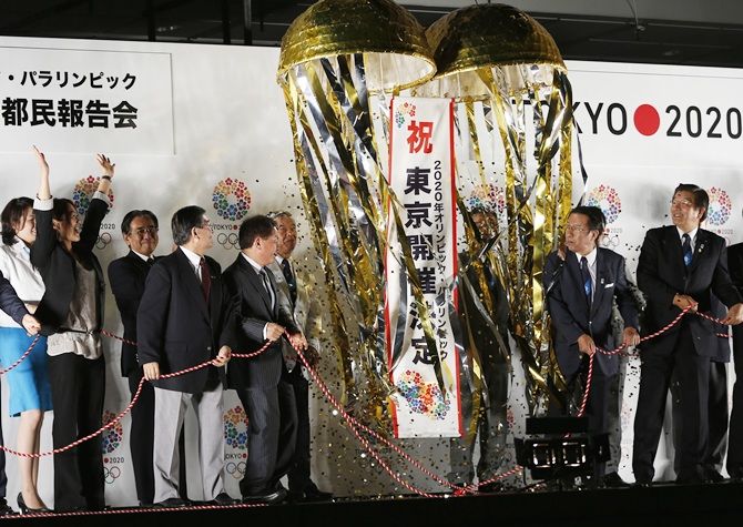 Members of the Tokyo bid committee open a decorative banner during an event titled "Tokyo 2020   Host City Welcoming Ceremony"