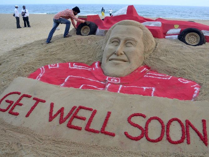  Indian sand artist Sudarshan Pattnaik works on a sand sculpture of Michael Schumacher to   wish him a speedy recovery at Puri