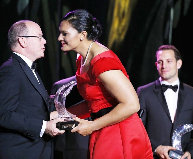 Shot putter Valerie Adams of New Zealand, centre, receives her 2014 IAAF Athlete of the Year trophy from Prince Albert II of Monaco