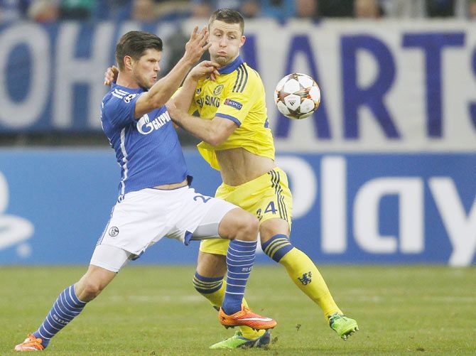 Schalke 04's Klaas-Jan Huntelaar challenges Chelsea's Gary Cahill (right) 