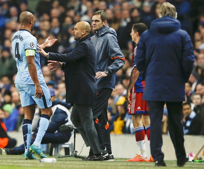 Manchester City's Vincent Kompany (left) is held back by Bayern Munich's coach Pep Guardiola after a foul by Bayern Munich's Robert Lewandowski (2nd from right) during their Champions League Group E match in Manchester on Tuesday