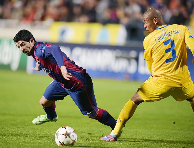 APOEL Nicosia's Joao Guilherme (right) and Barcelona's Luis Suarez fight for the ball during their Champions League Group F match on Tuesday