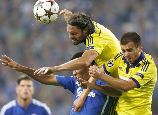 Schalke 04's Eric Maxim Choupo-Moting jumps for a header with Maribor's Marko Suler