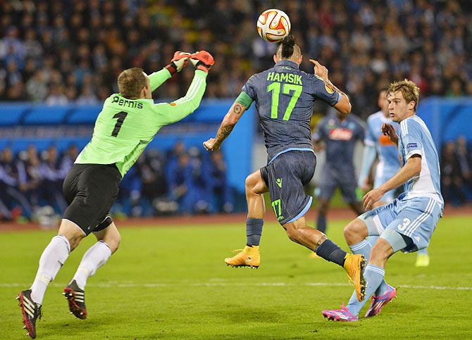 Marek Hamsik (centre) of Napoli scores past Slovan Bratislava goalkeeper Dusan Pernis (left) and Branislav Ninaj during their Europa League group I football match at the Arena Pasienky in Bratislava on Thursday