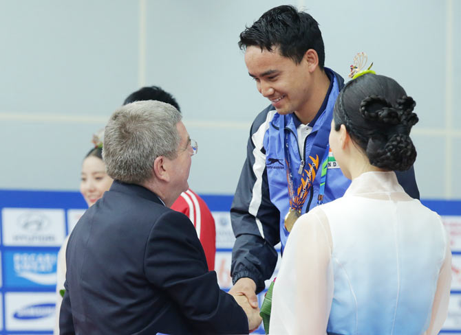 IOC President Thomas Bach presents Rai Jitu of India with his gold medal in the 50m Pistol Men's event at Ongnyeon International Shooting Range