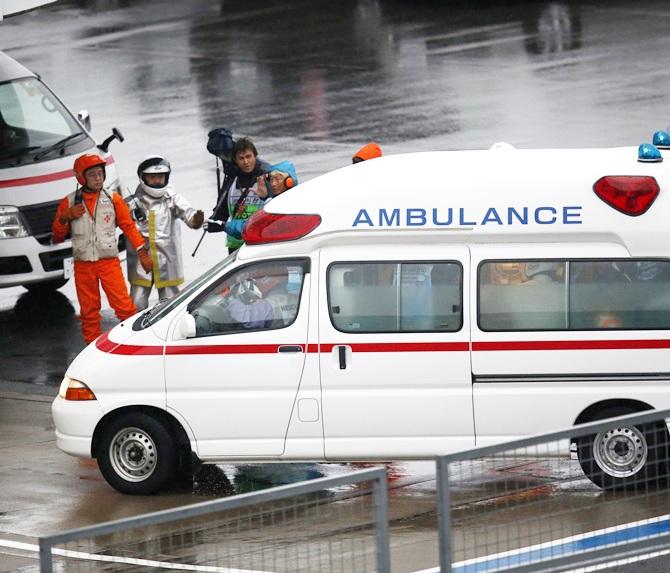 Marshalls clear the way for an ambulance after the race was stopped