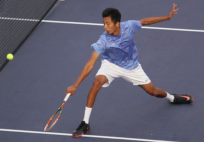 Chuhan Wang of China returns a shot during his match against Fabio Fognini of Italy during the day 3 of the Shanghai Rolex Masters at the Qi Zhong Tennis Center on October 7, 2014 in Shanghai, China