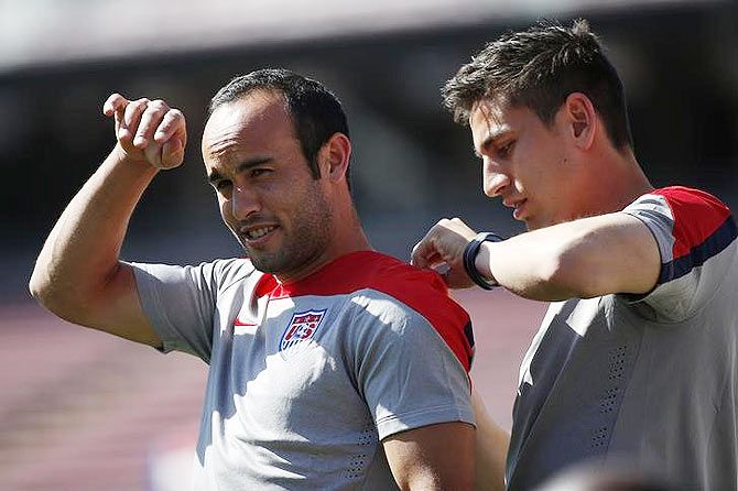 Landon Donovan (L) of the U.S. men's national soccer team, is helped by a teammate during the team's World Cup training camp 