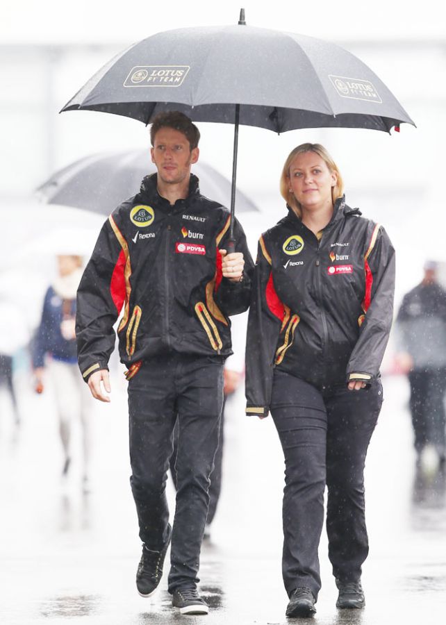 Romain Grosjean of France and Lotus walks across a wet paddock prior to the Japanese Formula One Grand Prix