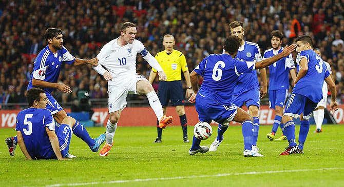England's Wayne Rooney (3rd from left) has his path blocked by the San Marino defence during their Euro 2016 qualifying soccer match at Wembley Stadium