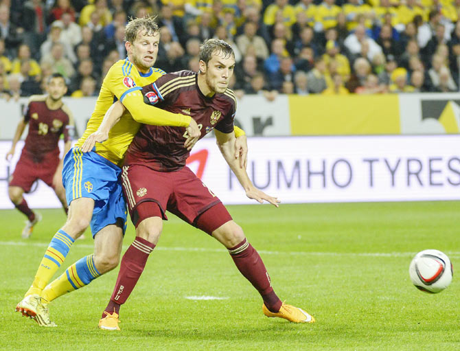 Sweden's Mikael Antonsson (L) fights for the ball with Russia's Artem Dzyuba during their Euro 2016 qualifying soccer match at Friends Arena in Stockholm