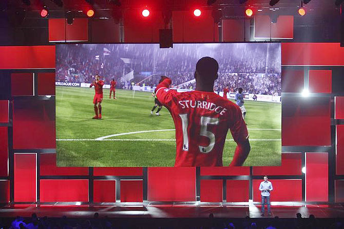 People watch a demonstration of "FIFA 15" at the Electronic Arts (EA) World Premiere: E3 2014 Preview press conference at the Shrine Auditorium in Los Angeles, California