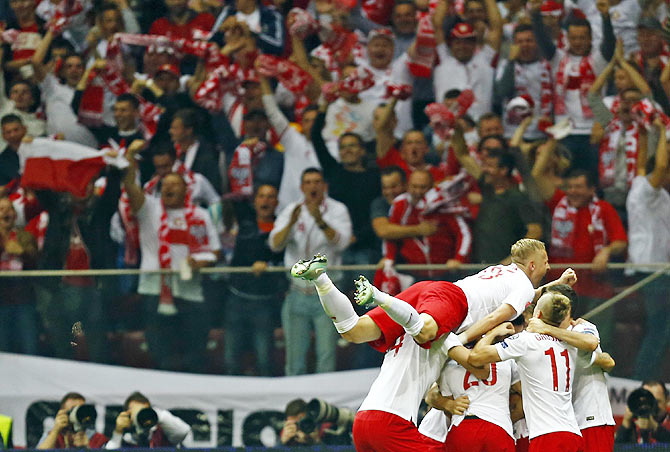 Poland's Arkadiusz Milik (right) celebrates with teammates after scoring against Germany during their Euro 2016 group D qualifying match at the National stadium in Warsaw on Saturday