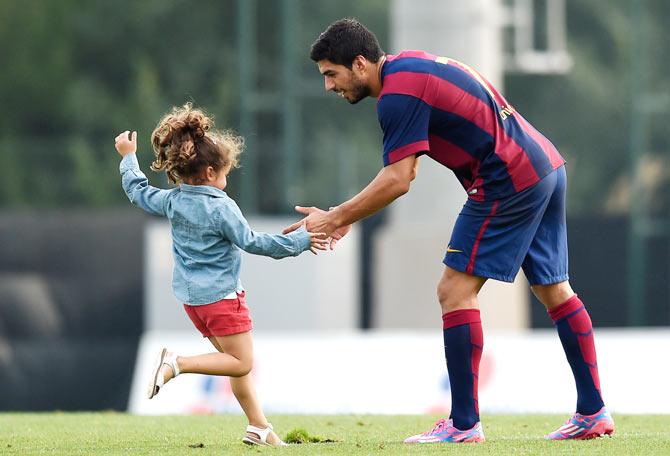 Luis Suarez of FC Barcelona hugs to his daughter Delfina Suarez after a friendly match between FC Barcelona B and Indonesia U19 at Ciutat Esportiva on September 24