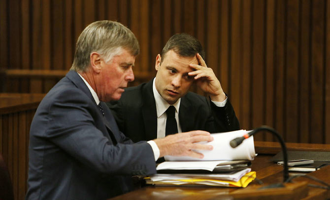 Oscar Pistorius talks to one of his legal representatives Brian Webber in the Pretoria High Court for sentencing in his murder trial on Thursday