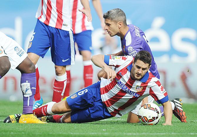 Koke of Club Atletico de Madrid is tackled by Salva Sevilla of RCD Espanyol during their La Liga match at Vicente Calderon Stadium in Madrid on Sunday