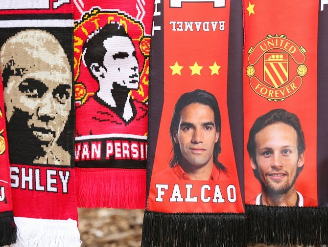 A vendor sells scarves showing new signings Falcao and Daley Blind