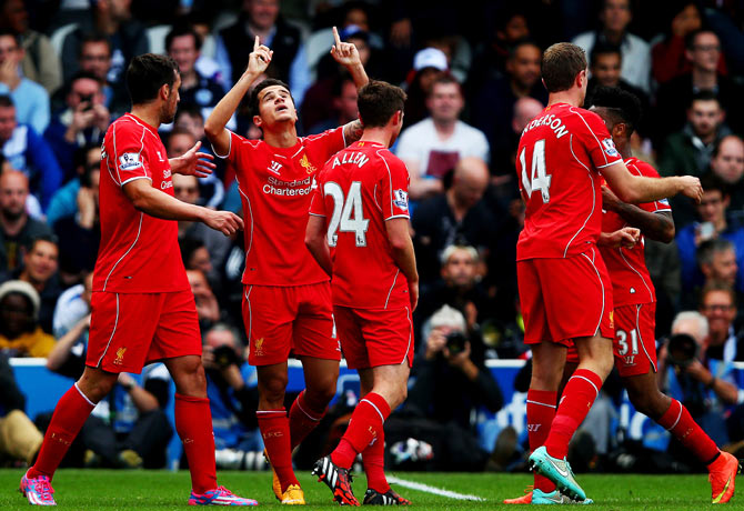 Philippe Coutinho of Liverpool celebrates with teammates after scoring against Queens Park Rangers during their English Premier League match at Loftus Road in London on Sunday