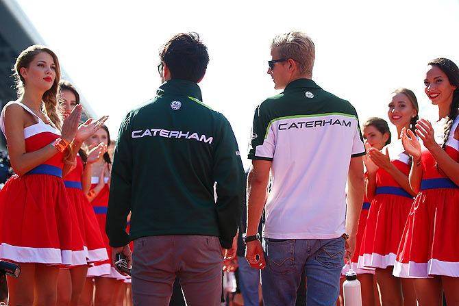 Kamui Kobayashi of Japan and Caterham and Marcus Ericsson of Sweden and Caterham walk out