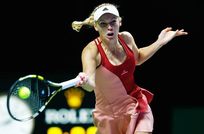 Caroline Wozniacki of Denmark in action against Agnieszka Radwanska of Poland during their WTA Finals tennis match at the Singapore Sports Hub on Thursday