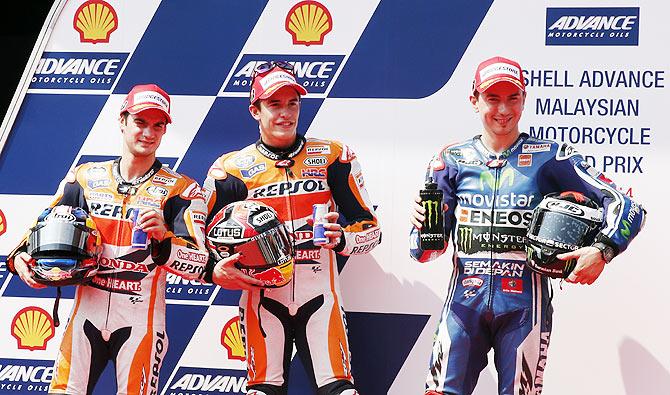 Honda MotoGP rider Dani Pedrosa of Spain, Honda MotoGP rider Marc Marquez of Spain and Yamaha MotoGP rider Jorge Lorenzo of Spain pose for photographs after the qualifying round of the Malaysian Grand Prix at Sepang International Circuit near Kuala Lumpu