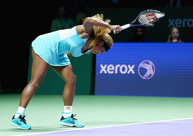 Serena Williams of the United States shows her frustration as she smashes her racket on the court during her semi-final against Caroline Wozniacki of Denmark at the WTA Finals in Singapore on Saturday