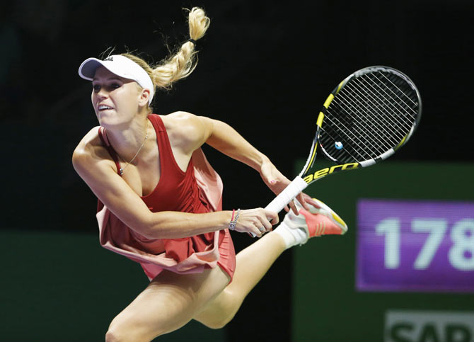 Caroline Wozniacki of Denmark serves against Serena Williams of the US during their WTA Finals singles semi-finals at the Singapore Indoor Stadium on Saturday