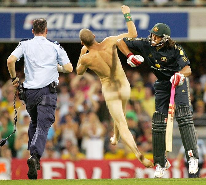 Andrew Symonds of Australia knocks over a streaker 